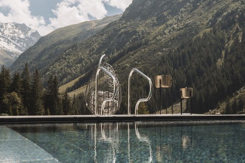 Bilder aus der Sportalm Pool vor Berglandschaft mit Sonnenschein und Wolken