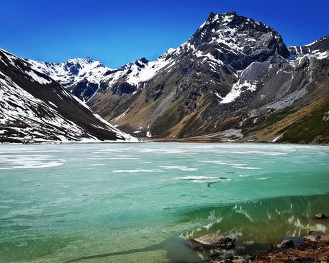Pictures from Sportalm Frozen mountain lake with snow-capped peaks under clear blue sky