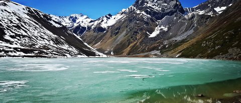 Pictures from Sportalm Frozen mountain lake with snow-capped peaks under clear blue sky