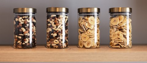 Pictures from Sportalm Four jars with nuts and banana chips on a wooden shelf