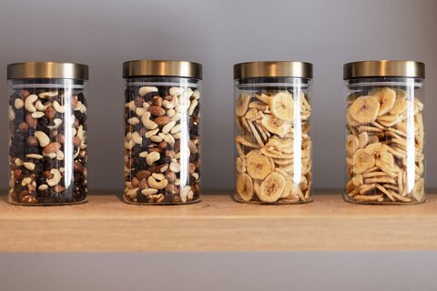 Pictures from Sportalm Four jars with nuts and banana chips on a wooden shelf