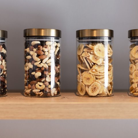 Pictures from Sportalm Four jars with nuts and banana chips on a wooden shelf