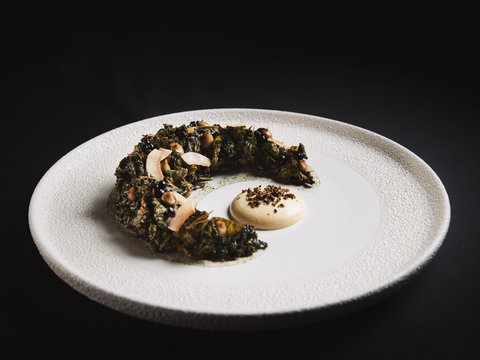 Bilder aus der Sportalm Kunstvoll angerichtetes Gericht mit einer grünen, kreisförmigen Komponente und Sauce auf weißem Teller