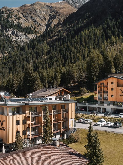 Pictures from Sportalm Hotel buildings surrounded by mountains and forests on a sunny day
