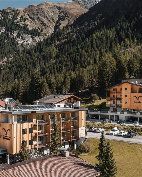 Pictures from Sportalm Hotel buildings surrounded by mountains and forests on a sunny day