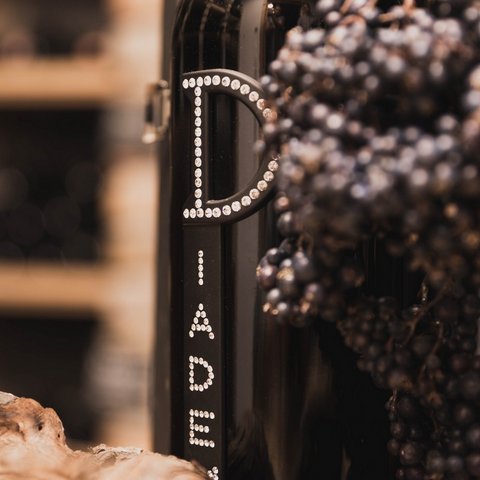 Bilder aus der Sportalm Weinflasche neben Trauben und Korken in einer warmen Atmosphäre