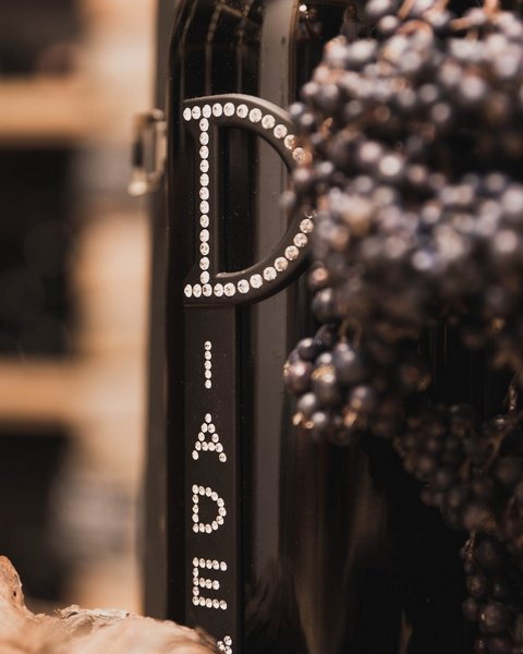 Bilder aus der Sportalm Weinflasche neben Trauben und Korken in einer warmen Atmosphäre