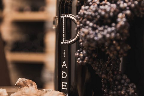 Bilder aus der Sportalm Weinflasche neben Trauben und Korken in einer warmen Atmosphäre