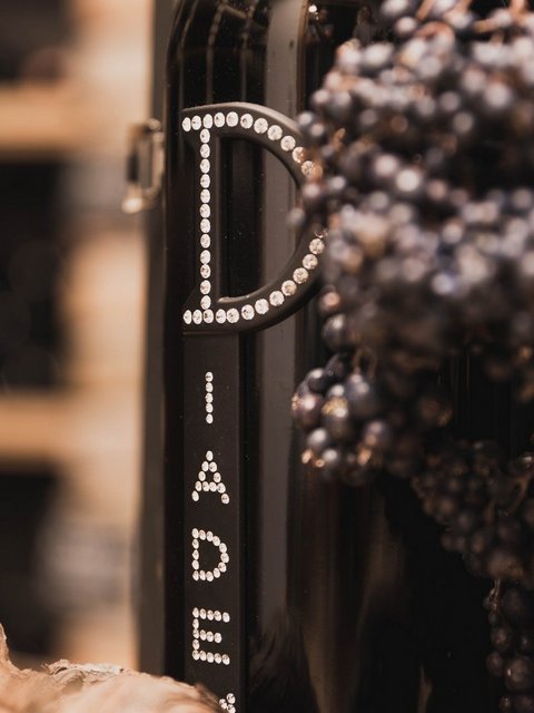 Bilder aus der Sportalm Weinflasche neben Trauben und Korken in einer warmen Atmosphäre