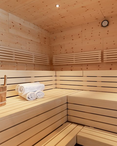 Bilder aus der Sportalm Innenraum einer Sauna mit Holzbank, Handtüchern und Holzeimer