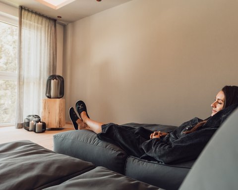 Pictures from Sportalm Woman relaxing on sofa in bright room with candle lights