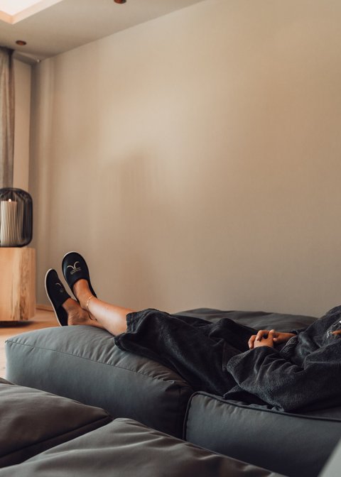 Pictures from Sportalm Woman relaxing on sofa in bright room with candle lights