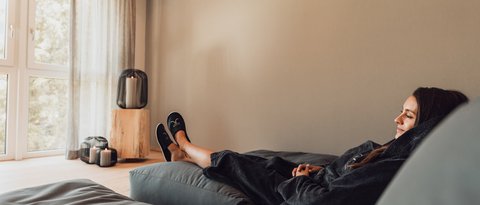 Pictures from Sportalm Woman relaxing on sofa in bright room with candle lights