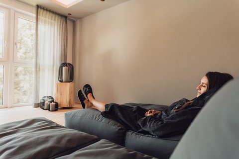 Pictures from Sportalm Woman relaxing on sofa in bright room with candle lights