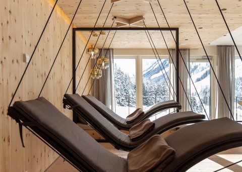 Pictures from Sportalm Modern hanging loungers with pillows in wood room with mountain view