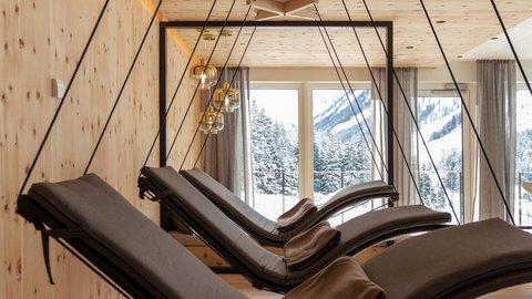 Pictures from Sportalm Modern hanging loungers with pillows in wood room with mountain view