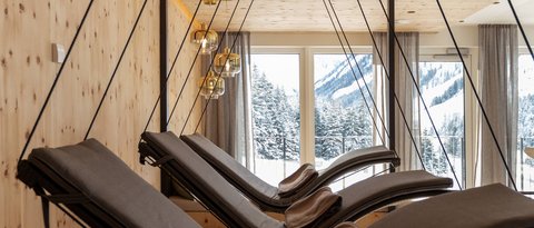 Pictures from Sportalm Modern hanging loungers with pillows in wood room with mountain view