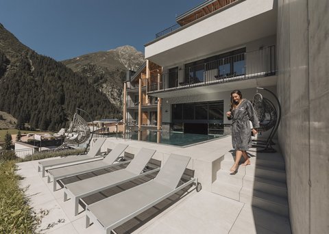 Pictures from Sportalm Woman in robe by the pool area of a mountain hotel