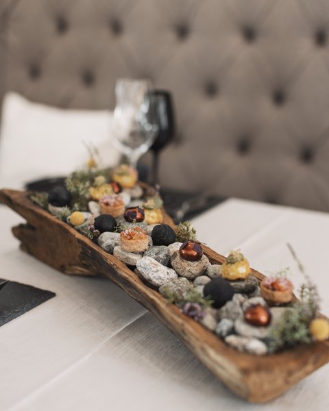 Bilder aus der Sportalm Vorspeisen auf Steinen in einem rustikalen Holztablett serviert