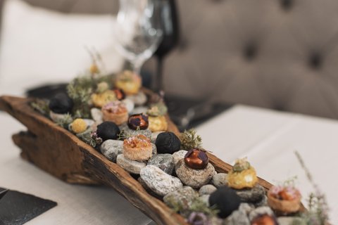 Bilder aus der Sportalm Vorspeisen auf Steinen in einem rustikalen Holztablett serviert