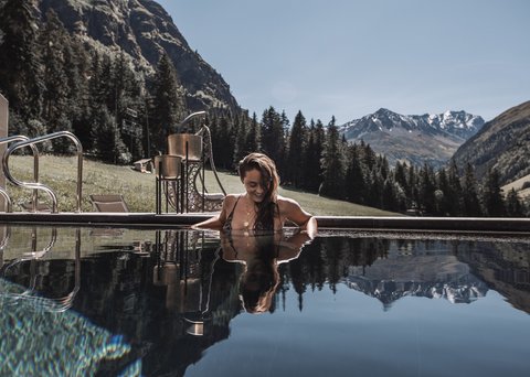Pictures from Sportalm Woman relaxing in pool with mountain scenery in the background