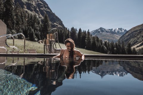 Bilder aus der Sportalm Frau entspannt im Pool mit Bergpanorama im Hintergrund