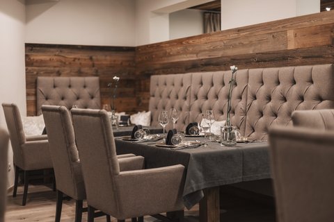 Bilder aus der Sportalm Eleganter Esstisch mit Stühlen und dunkelgrauem Tischset in gemütlichem Restaurant