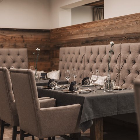 Pictures from Sportalm Elegant dining table with chairs and dark gray tablecloth in cozy restaurant