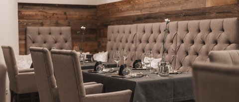 Pictures from Sportalm Elegant dining table with chairs and dark gray tablecloth in cozy restaurant