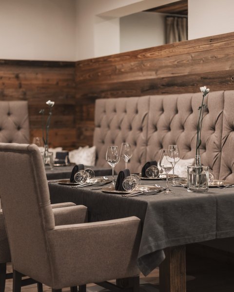 Bilder aus der Sportalm Eleganter Esstisch mit Stühlen und dunkelgrauem Tischset in gemütlichem Restaurant