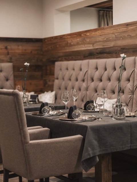 Pictures from Sportalm Elegant dining table with chairs and dark gray tablecloth in cozy restaurant