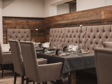 Unser Restaurant im Pitztal Eleganter Esstisch mit Stühlen und dunkelgrauem Tischset in gemütlichem Restaurant