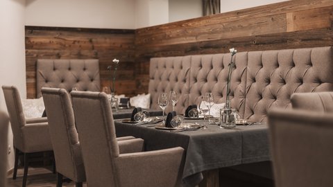 Pictures from Sportalm Elegant dining table with chairs and dark gray tablecloth in cozy restaurant