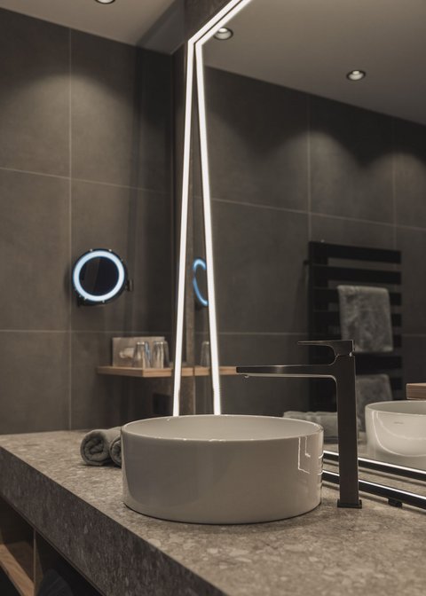 Bilder aus der Sportalm Moderner Badwaschtisch mit rundem Waschbecken und beleuchtetem Spiegel