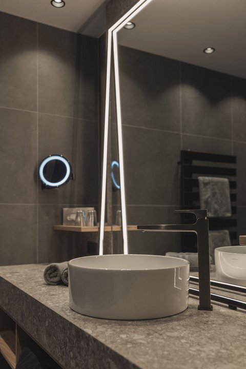 Bilder aus der Sportalm Moderner Badwaschtisch mit rundem Waschbecken und beleuchtetem Spiegel