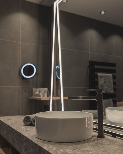 Bilder aus der Sportalm Moderner Badwaschtisch mit rundem Waschbecken und beleuchtetem Spiegel