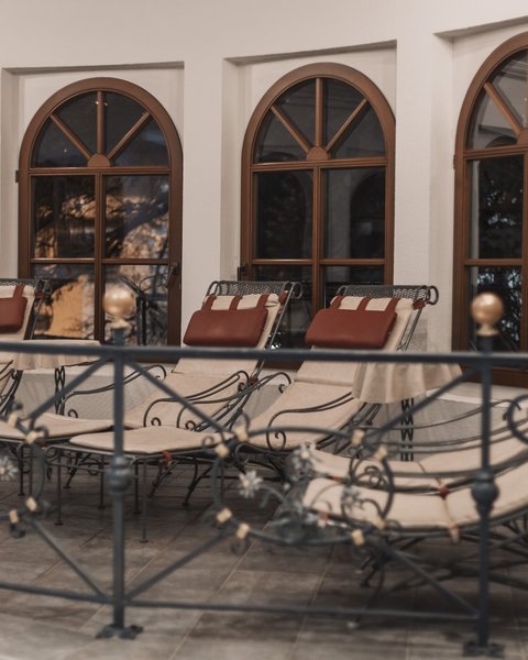 Pictures from Sportalm Several padded lounge chairs in front of arched windows inside a room