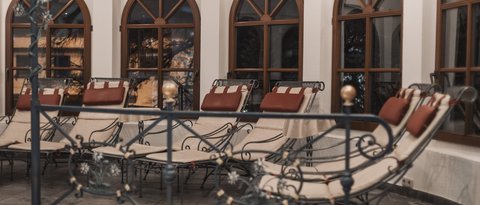 Pictures from Sportalm Several padded lounge chairs in front of arched windows inside a room