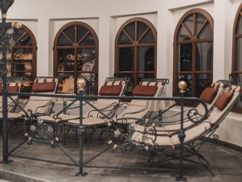 Bilder aus der Sportalm Mehrere gepolsterte Loungesessel vor bogenförmigen Fenstern in einem Innenraum