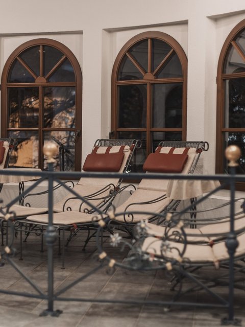 Pictures from Sportalm Several padded lounge chairs in front of arched windows inside a room