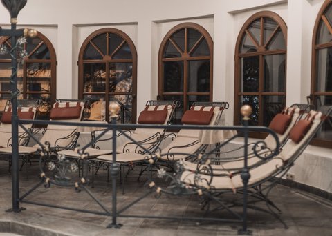 Pictures from Sportalm Several padded lounge chairs in front of arched windows inside a room