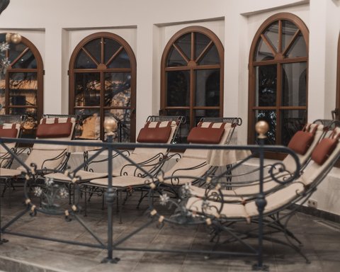 Pictures from Sportalm Several padded lounge chairs in front of arched windows inside a room