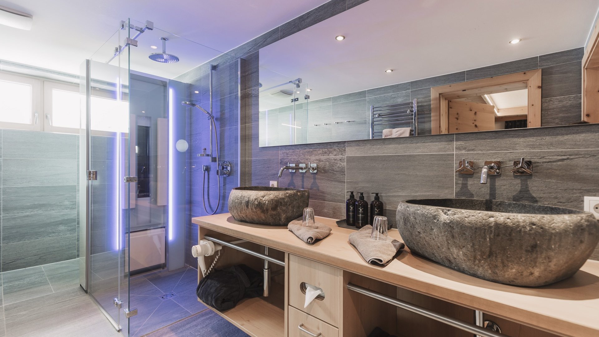 Everything about your Sportalm holiday Modern bathroom with natural stone sinks and glass shower