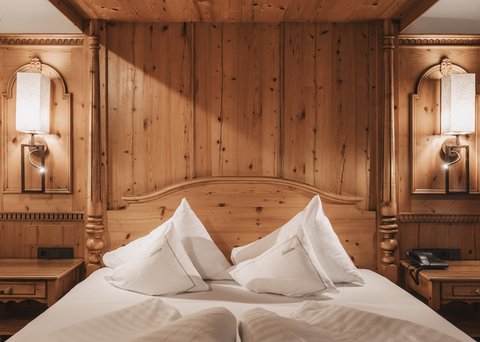 Pictures from Sportalm Cozy wooden bed with white pillows and nightstands with lamps