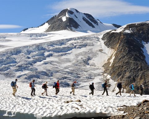 Bilder aus der Sportalm Gruppe von Wanderern auf verschneitem Bergpfad mit Berg im Hintergrund