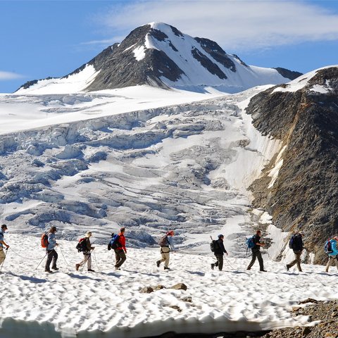 Pictures from Sportalm Group of hikers on snowy mountain trail with mountain in background