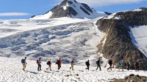 Pictures from Sportalm Group of hikers on snowy mountain trail with mountain in background