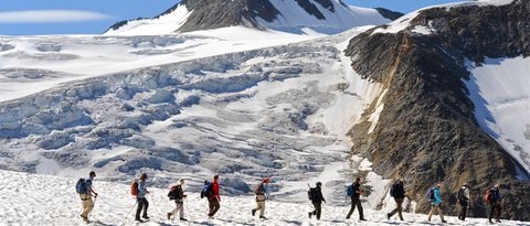 Bilder aus der Sportalm Gruppe von Wanderern auf verschneitem Bergpfad mit Berg im Hintergrund