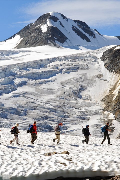 Pictures from Sportalm Group of hikers on snowy mountain trail with mountain in background