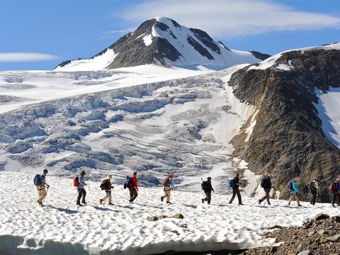 Bilder aus der Sportalm Gruppe von Wanderern auf verschneitem Bergpfad mit Berg im Hintergrund